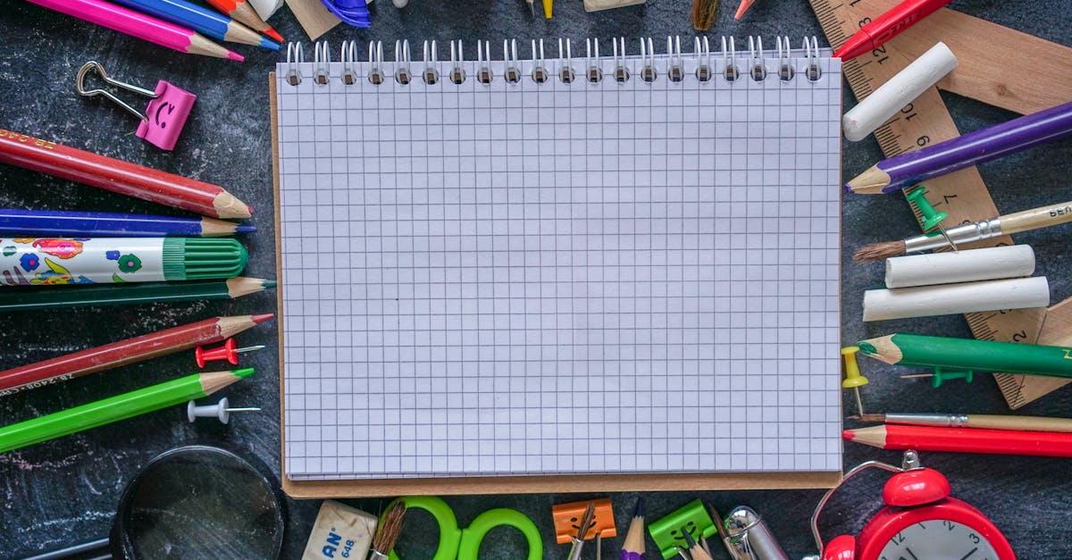 Mãos desenhando um mapa mental em papel com laptop, post-its e anotações, visão superior.