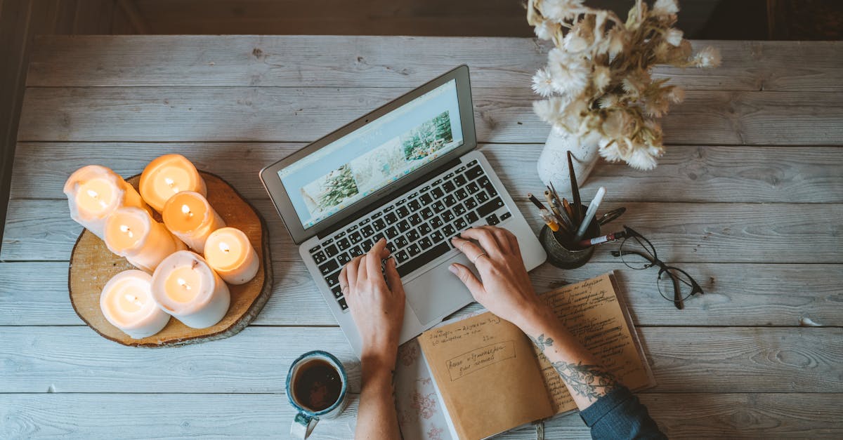 Mesa com laptop, caderno de rascunhos, cronômetro e mãos escrevendo um outline