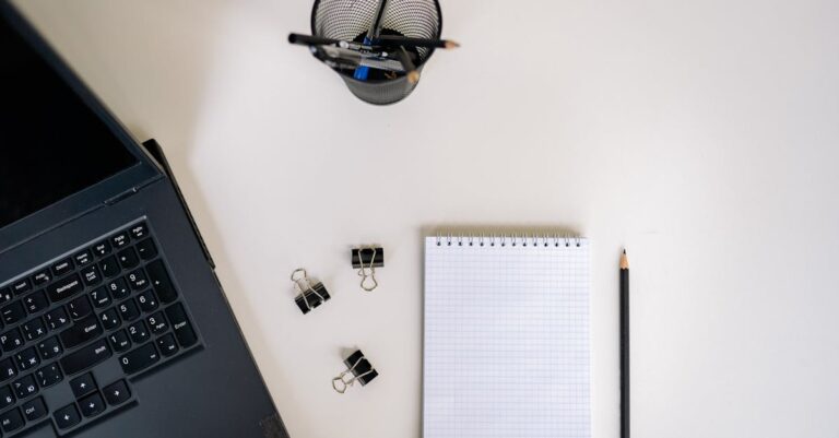 Prancheta com checklist rápido, caneta ao lado e laptop prontos para verificação final