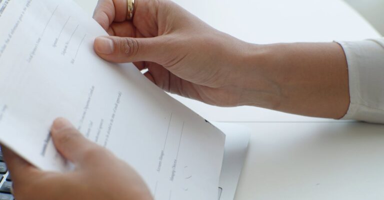 Mãos digitando carta de resposta no laptop, com checklist ao lado
