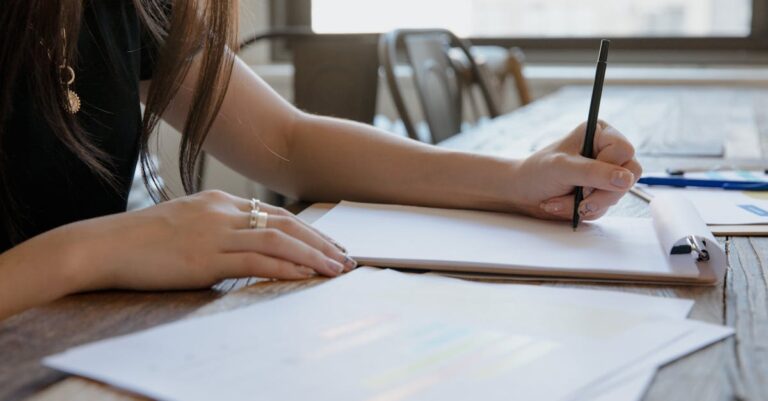 Mãos trocando mapa mental no escritório, simbolizando estudante, orientador e suporte institucional.