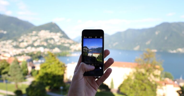 Smartphone com app de pronúncia aberto e fones sobre a mesa para prática e feedback imediato