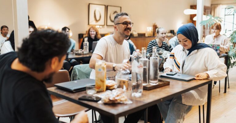 Reunião entre pesquisador(es) e atores locais, mesa com laptop, cadernos e mãos visíveis