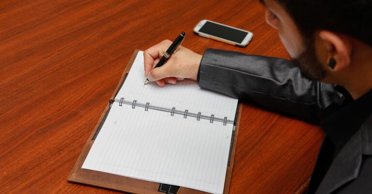 Checklist em papel e celular com alarmes, mãos configurando lembrete para microtarefas