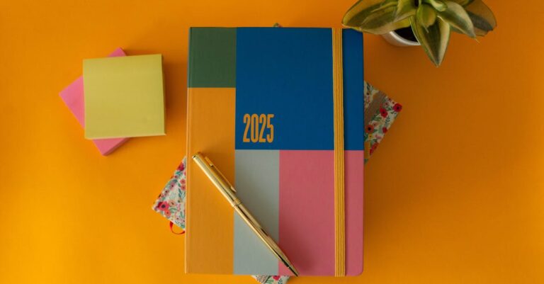 Calendário e planner com cronograma de revisão, post-its e cronômetro sobre mesa.