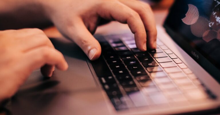 Tela com registros de auditoria e mãos no teclado, foco em logs e metadados