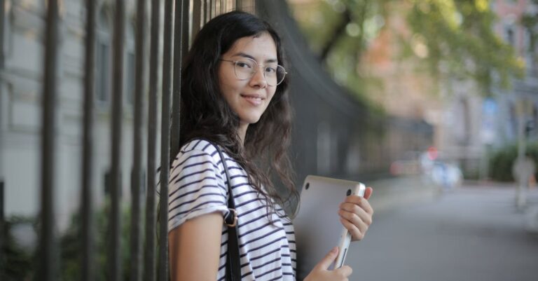 Computador com template acadêmico aberto e guia institucional impresso ao lado, mãos apontando