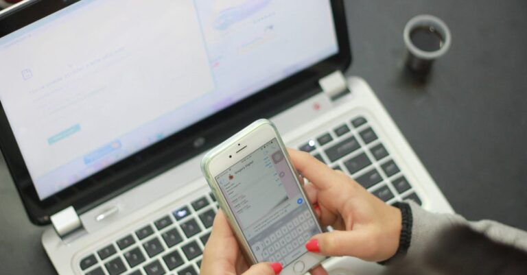Mãos fazendo upload de PDFs no laptop, progresso de envio visível na tela do sistema
