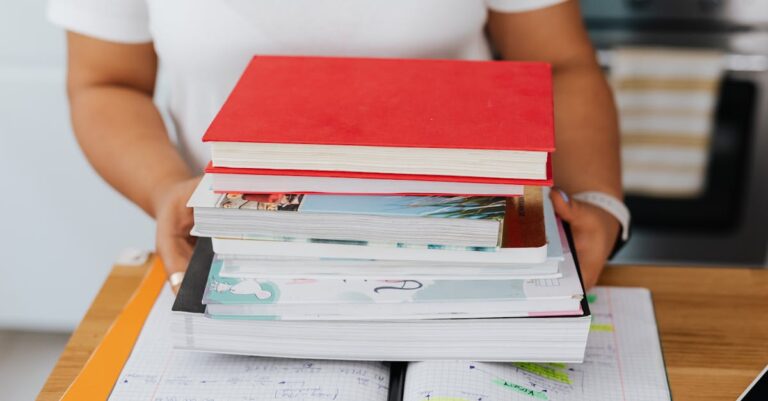 Laptop com artigo aberto, pilha de livros e notas com citações e marcações