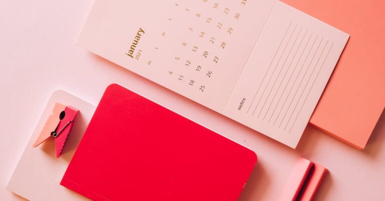 Prancheta com checklist ao lado de calendário e laptop, organização logística para defesa.
