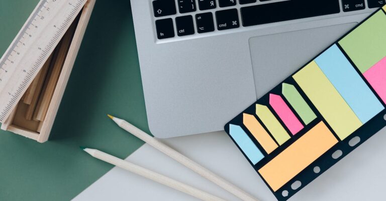 Agenda, laptop e pastas com prazos e lembretes, vista superior para organização de inscrições.