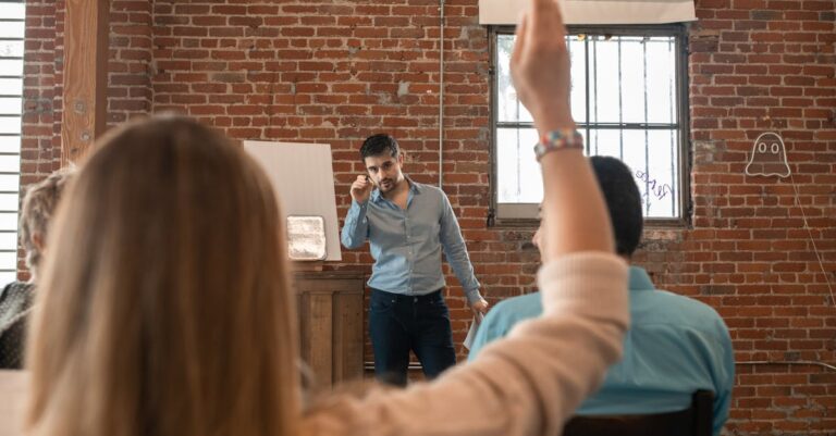 Apresentação em seminário com projeção e público desfocado, foco nas mãos e slides