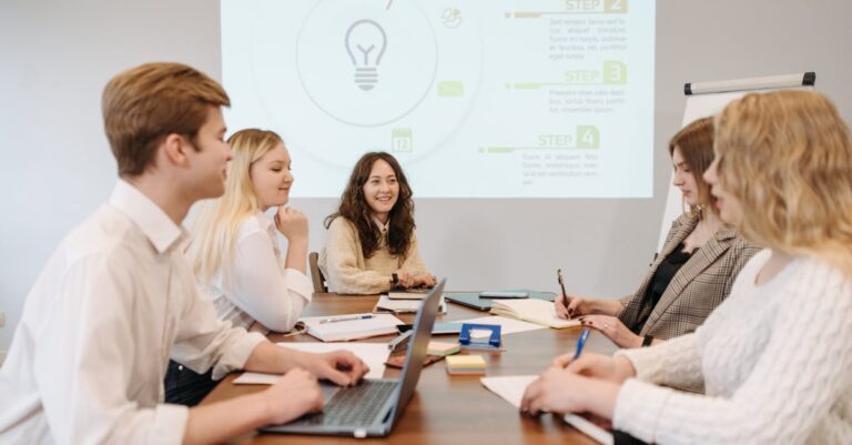 Ensaio com colegas em sala de reunião, laptop e projetor visíveis, dinâmica de prática