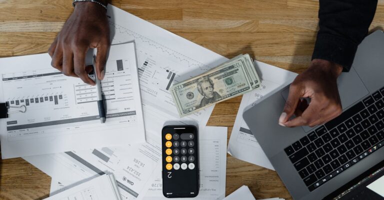 Planilha com orçamento e gráficos ao lado de laptop e calculadora