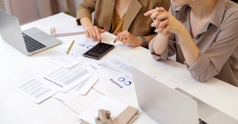 Computador com gráficos, caderno e cronômetro para registrar métricas de produtividade