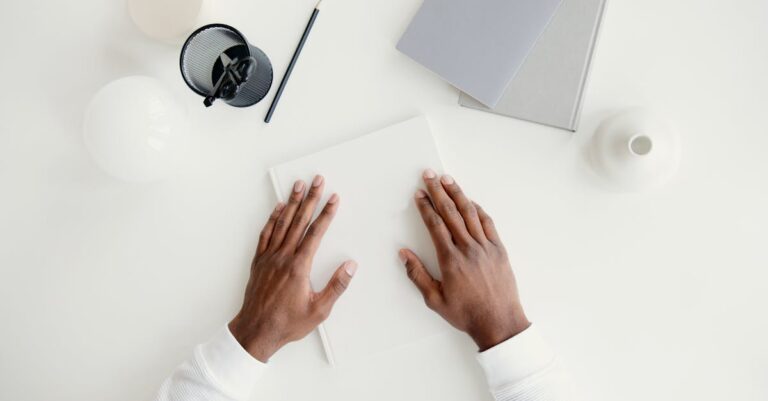 Mesa com laptop aberto em template de documento e livros de referências, vista superior