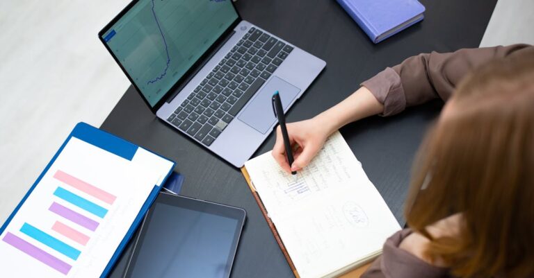 Mesa com laptop, gráficos impressos e anotações de estudo de caso sobre políticas públicas