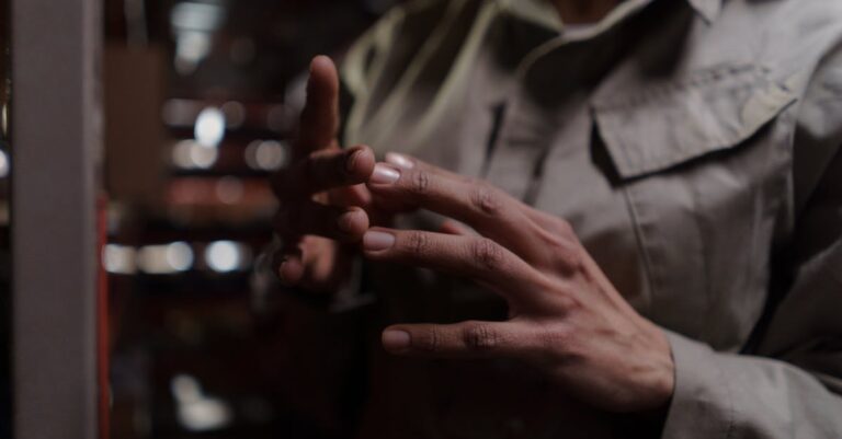 Mãos assinando termo de bolsa sobre mesa, com extrato bancário e calendário ao lado.