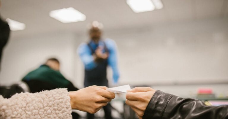 Mãos trocando cartões de contato e anotações entre colegas ao fim de uma aula.