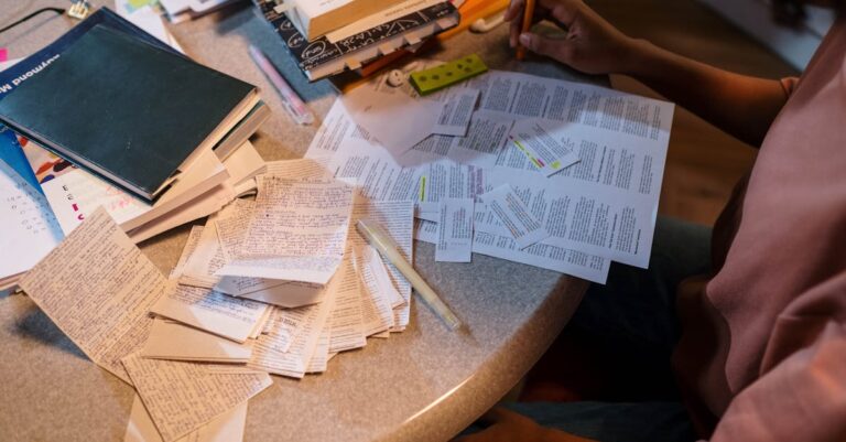 Artigos anotados com post-its e marcações sobre a mesa, simbolizando validação e revisão de evidências.