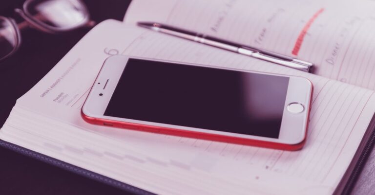 Smartphone com agenda e app pomodoro ao lado de caderno com notas sobre serviços institucionais
