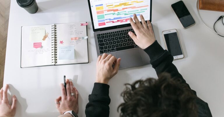 Caderno com gráficos simples, sticky notes e laptop com dashboard, representando indicadores e monitoramento