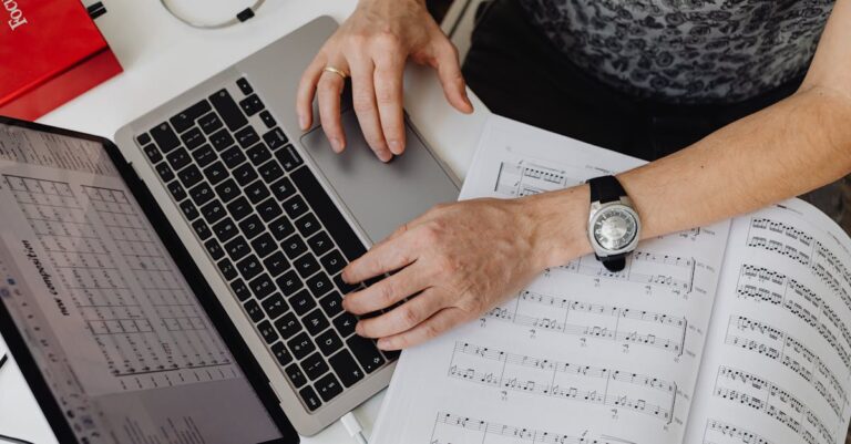 Mãos organizando notas e slides no laptop, montagem de apresentação a partir de fichamentos