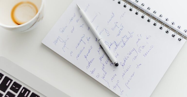 Laptop com prompt de exemplo na tela (texto desfocado) e caderno com anotações ao lado.