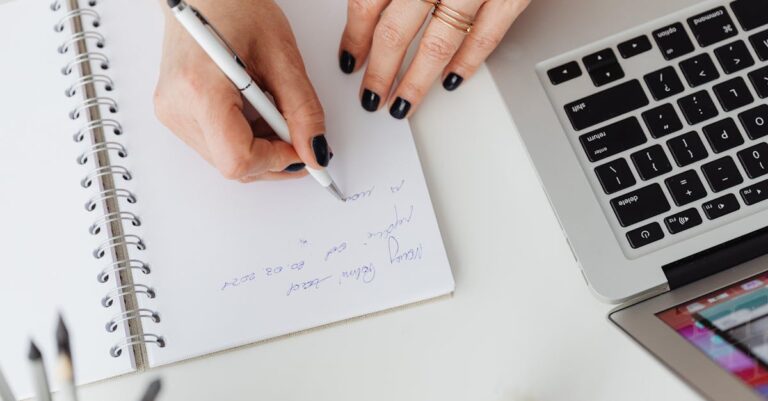 Mãos anotando em caderno ao lado de laptop, registro de uso em destaque.