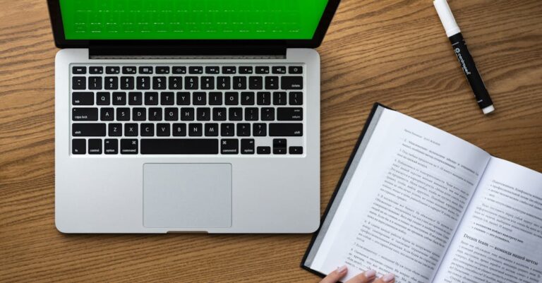 Laptop com várias janelas de ferramentas acadêmicas abertas e caderno ao lado, vista superior.
