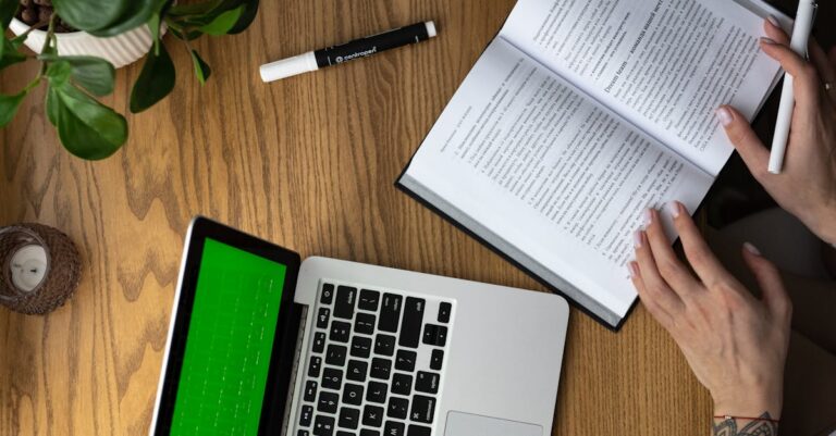 Notebook aberto, rascunhos de pré‑projeto e bibliografia sobre a mesa