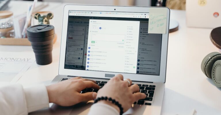 Mãos digitando e-mail no laptop com PDF do projeto aberto na tela, sugerindo contato breve com orientadores.