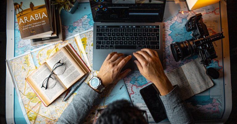 Laptop e caderno com palavras-chave destacadas e mãos apontando para a tela