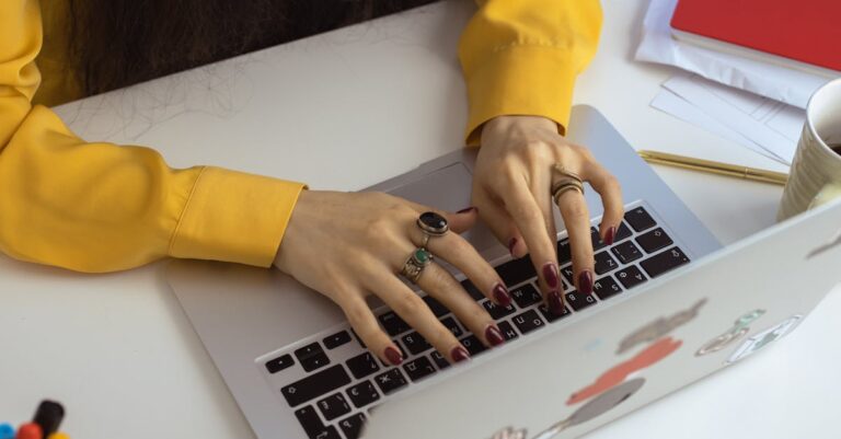 Mãos digitando mensagem no laptop sobre mesa de estudo, preparando contato com orientador