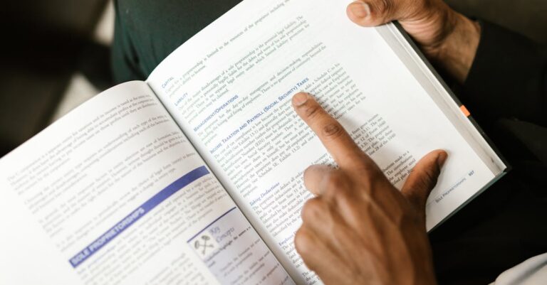 Mãos apontando para um template de artigo sobre a mesa, discutindo estrutura e submissão