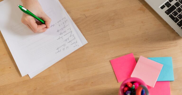 Notebook com template de tese aberto, folhas impressas e notas adesivas, vista aérea