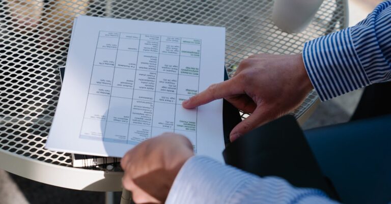 Mãos sobre documentos e laptop revisando diretrizes e políticas sobre uso de IA em pesquisa