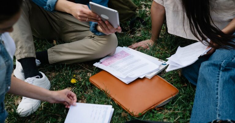 Mãos de estudante e profissional sobre mesa com caderno aberto, simbolizando acolhimento institucional