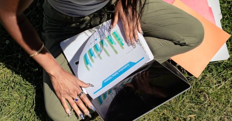 Mesa com laptop e gráficos, artigos impressos e anotações que representam estudos sobre produtividade e riscos