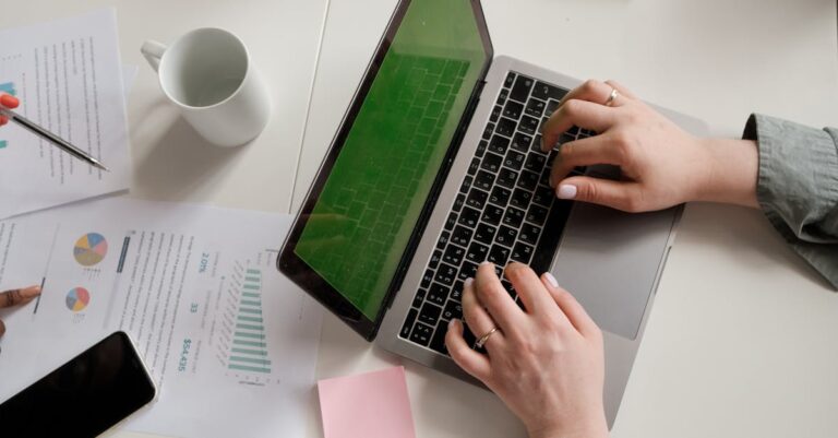 Mãos digitando e‑mail ao lado do CV e resumo do projeto, em ambiente de escritório