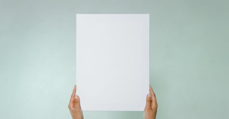 Mãos segurando prova impressa de pôster com impressora de grande formato ao fundo