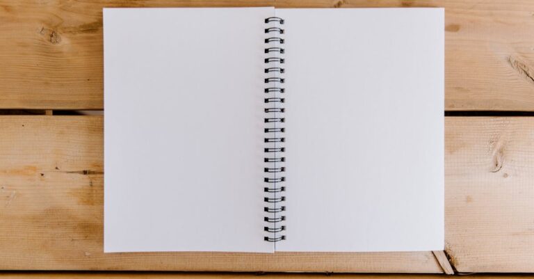 Mesa com laptop aberto em tese, pilha de periódicos e rascunho de carta, simbolizando avaliação acadêmica