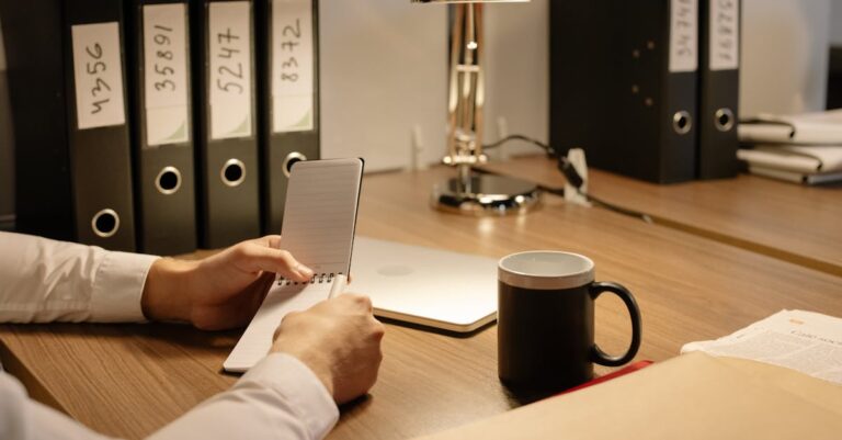 Duas pessoas apontando para um mapa mental impresso sobre a mesa, apenas mãos visíveis