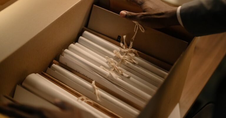 Pastas e fichários organizados com documentos impressos e etiquetas, prontos para auditoria