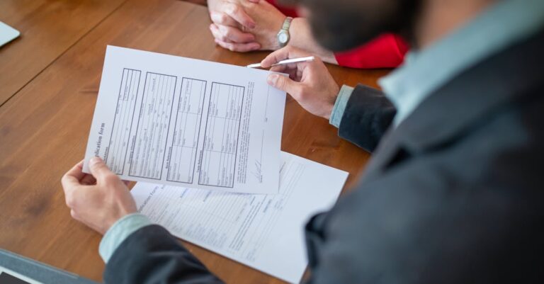 Professor conferindo documentos e comprovante de vínculo em mesa com checklist.