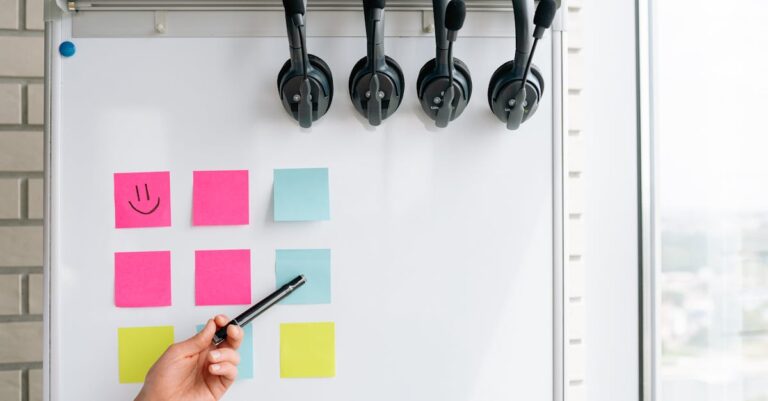 Mãos escrevendo em post-its e quadro branco com ideias, ilustrando técnicas de ideação em grupo.