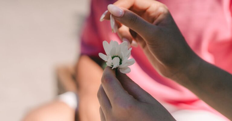 Mãos segurando diploma ao lado de documentos de inscrição e identidade sobre mesa