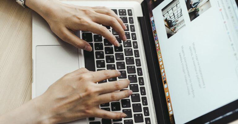 Mãos no teclado e lupa sobre a mesa, sugerindo revisão detalhada de dados e falhas.