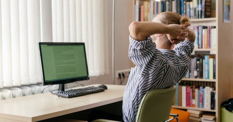 Tela de computador com página de modelos da biblioteca universitária e mão no mouse
