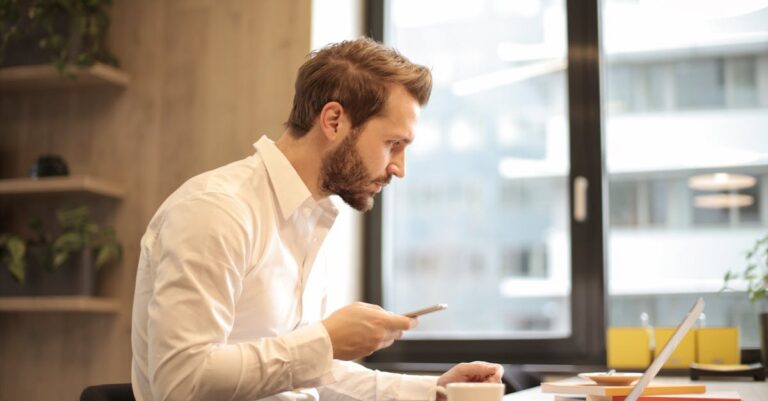 Pessoa escrevendo e‑mail acadêmico ao lado de resumo do projeto e CV em PDF sobre a mesa